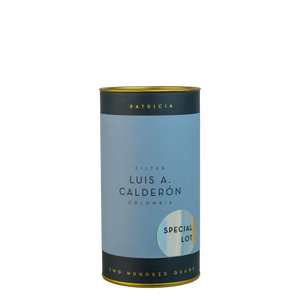 A navy blue cylinder with a blue label describes the roasted coffee beans within. 'PATRICIA' and 'TWO HUNDRED GRAMS' are printed in gold foil. A shiny round sticker reads 'SPECIAL LOT'